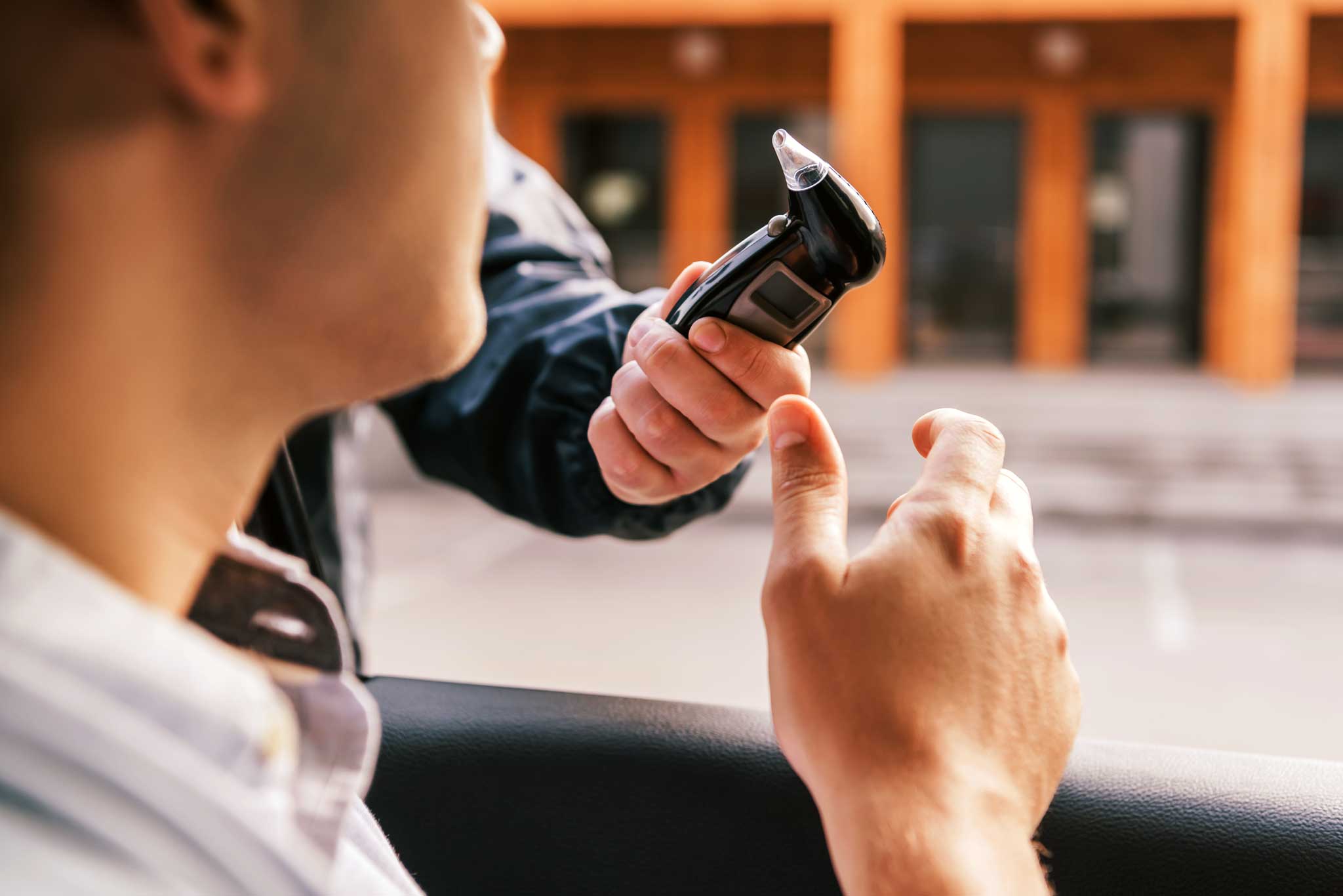 police officer bringing a man a marijuana breathalyzer to blow into