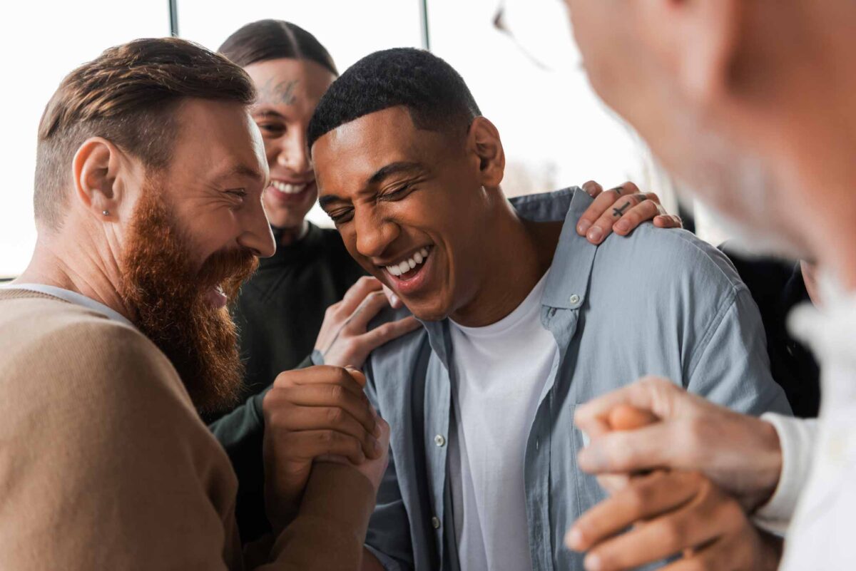 photo of a male group congratulating a young man for going through a long-term transitional living program